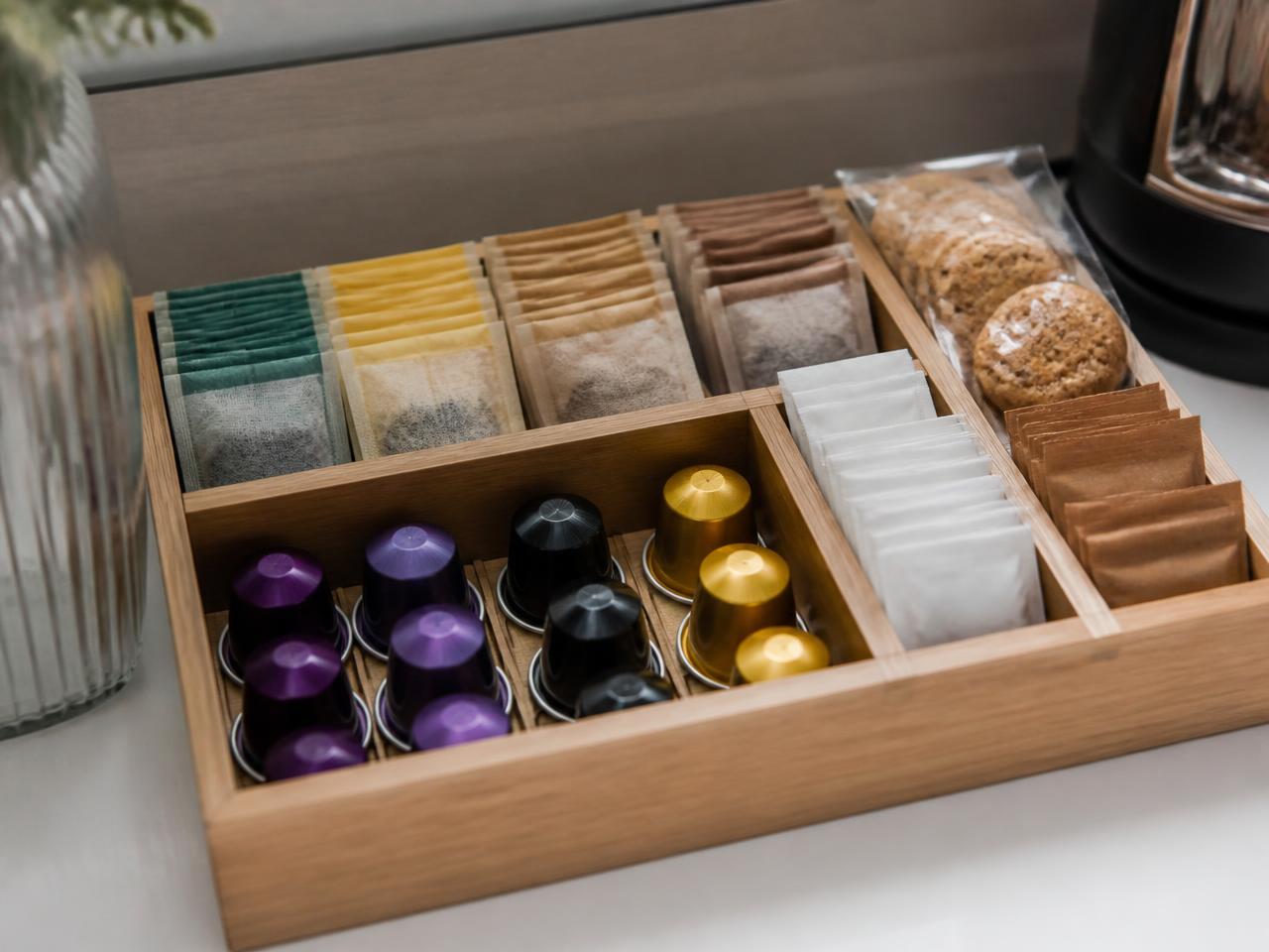 Bandeja de amenities con cápsulas de café, infusiones y azúcar ordenados en un apartamento turístico