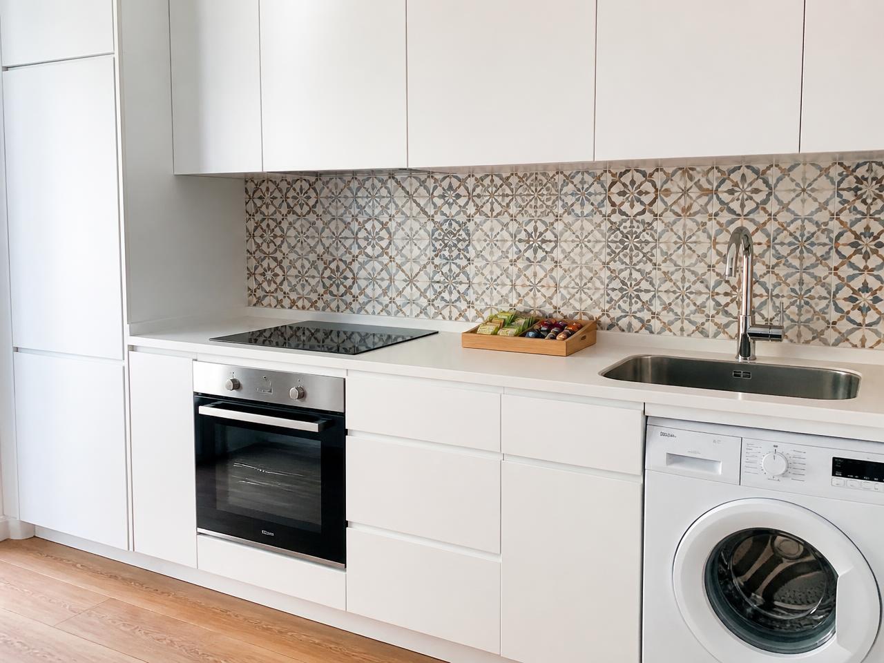 Cocina de apartamento turístico limpia con encimera despejada, fregadero pulido y bandeja de bienvenida